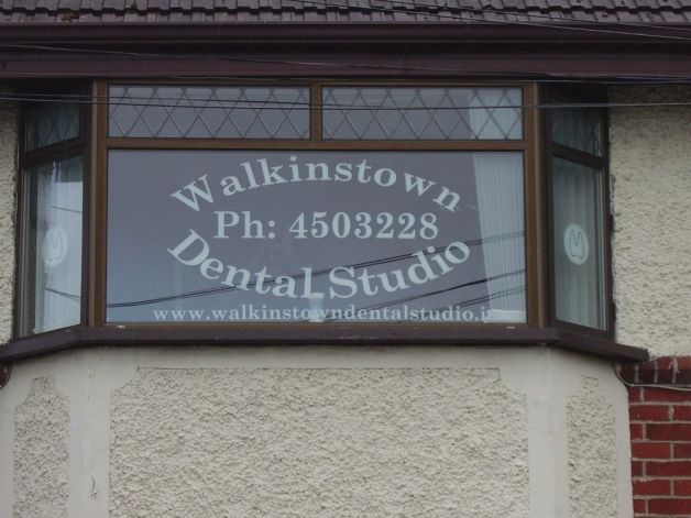 Close up of a window engraved with Walkinstown Dental Studio's contact details