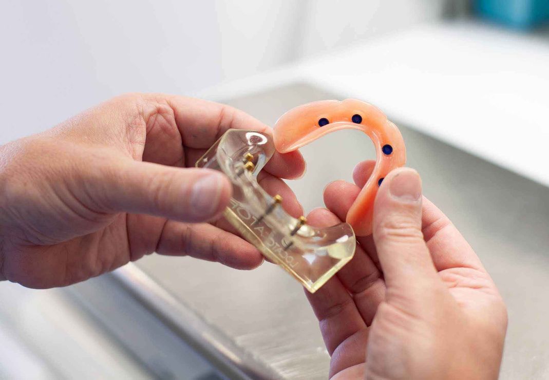 Dentist inspecting dentures